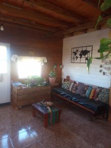 sala de estar con sofá y mesa en Cabaña Sion en Puerto Madryn