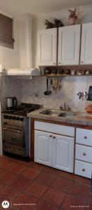 a kitchen with a stove and a sink at Mi Loft in Tandil +26 photos