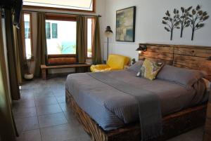 - une chambre avec un grand lit et une chaise jaune dans l'établissement Casa de huéspedes Tuga, à Ensenada
