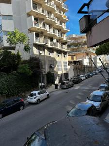 una calle con coches estacionados en el lateral de un edificio en La casa di Dafne en Messina