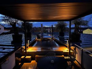 a deck with a table and chairs and an umbrella at Private Spa Loft in Roding +8 photos
