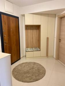 um quarto com uma cozinha com um tapete e armários de madeira em Central deluxe flat em Skopje