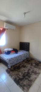 a bedroom with a bed in the corner of a room at Confortable habitación in Colonia Alamitos