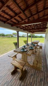 a wooden picnic table under a wooden roof at Estadia alegre ao som do mar in Maputo