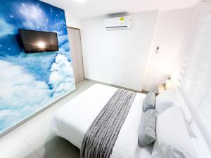 1 dormitorio con 1 cama y TV en la pared en Hostal El Cielo en Cartagena de Indias