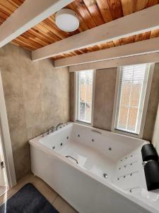 a large white tub in a bathroom with a window at WONDERLAND TİNY HOUSE in Sapanca