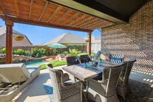 une terrasse avec une table, des chaises et une piscine dans l'établissement Modern Olympus View Oasis + Pool, à Waxahachie