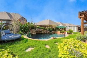un jardin avec une piscine et un banc dans l'établissement Modern Olympus View Oasis + Pool, à Waxahachie