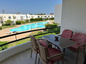 een balkon met een tafel en stoelen en een zwembad bij criss resort in Sharm El Sheikh