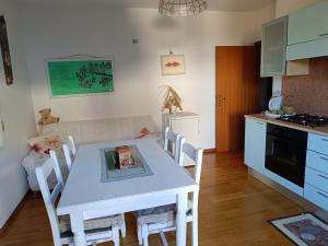 een keuken en eetkamer met een witte tafel en stoelen bij Famiglia Brochetti in Balbido-rango