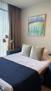 a bedroom with a bed with blue sheets and pillows at Cozy apartment with terrace, SJ Cosmopolitan Tower in San José
