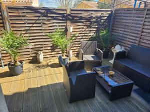 un patio con sillas, un sofá y una mesa en Maison tout confort en Nimes