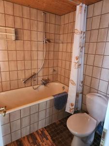 La salle de bains est pourvue d'une baignoire, de toilettes et d'une douche. dans l'établissement Apartment 31, im Zentrum Braunlage, à Braunlage