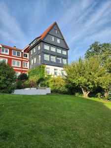 un grand bâtiment avec une pelouse verte devant lui dans l'établissement Apartment 31, im Zentrum Braunlage, à Braunlage
