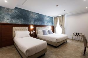 - une chambre avec 2 lits et un tableau mural dans l'établissement Esposizione Luxury Rome, à Rome
