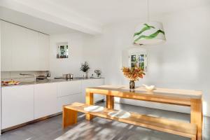 uma cozinha com armários brancos e uma mesa de madeira em Hiša Ana em Komen