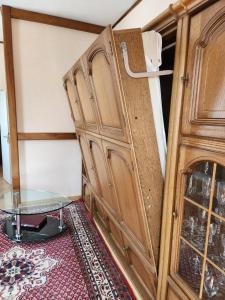 une armoire en bois dans une pièce avec une table en verre dans l'établissement Apartment 31, im Zentrum Braunlage, à Braunlage