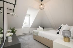 a white bedroom with a bed and a window at ENTR - Modern Apartments in Windsor with Parking in Windsor