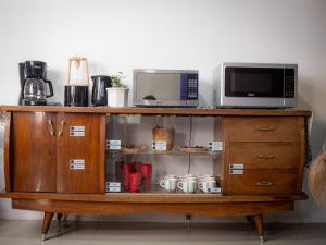 a wooden cabinet with a microwave on top of it at Lolas Hostal Hab. doble (baño privado) in San José