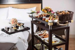 a tray of food on a bed next to a table of food at Hilton Lima Miraflores in Lima