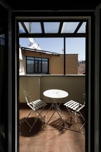 a table and chairs in a room with a window at Esposizione Luxury Rome in Rome