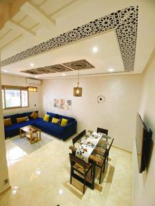 a living room with a blue couch and a table at Appartement calme in Fès