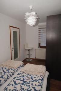 a bedroom with a bed and a chandelier at Apartman Alchemist I in Bosanska Dubica