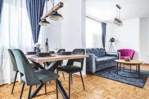 a living room with a table and chairs and a couch at Colors Of Urban City - Zagreb in Zagreb