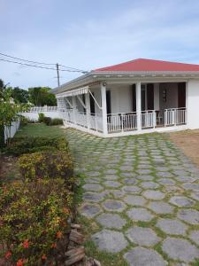 a house with a stone walkway in front of it at Villa Flora, escapade champêtre in Petit-Canal