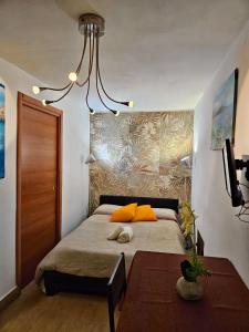 a bedroom with a bed with orange pillows and a chandelier at Happie Casa La Cattedrale in Palermo