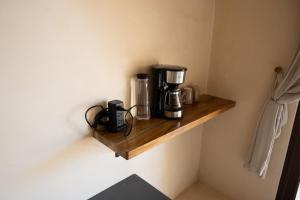eine Kaffeemaschine auf einem Holzregal an einer Wand in der Unterkunft Yax Kiin Casa Boutique in Puerto Morelos