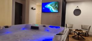 a large bath tub in a room with a tv at Aqua Rêve in Digne-les-Bains