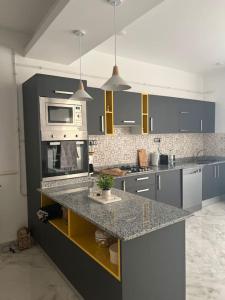 a kitchen with a counter with a microwave and a stove at Luxueux T3 à Oran. in Oran