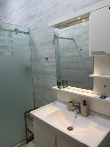 y baño con lavabo y espejo. en Luxueux T3 à Oran., en Orán