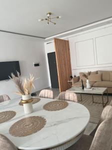 ein Wohnzimmer mit einem weißen Tisch und Stühlen in der Unterkunft Luxueux T3 à Oran. in Oran