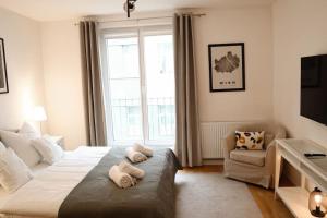 Un dormitorio con una cama grande con dos animales de peluche. en Charming, modern & spacious Apartment en Viena