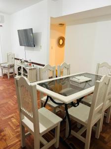 een eetkamer met een glazen tafel en stoelen bij Departamento Céntrico Tucumán 1B in San Miguel de Tucumán