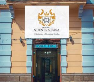 a sign over the entrance to a nitschia casas building at Hotel Nuestra Casa Riobamba in Riobamba