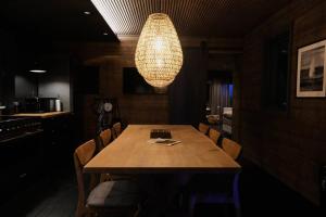 a dining room with a wooden table and a chandelier at Luxury 2-Bedroom Lodge in the South of Iceland in Reykholt