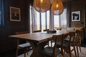 a dining room table with chairs and chandeliers at Luxury 2-Bedroom Lodge in the South of Iceland in Reykholt