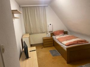 a small bedroom with a bed and a television at Monteurhaus bei EnergyFreund in Hallstadt