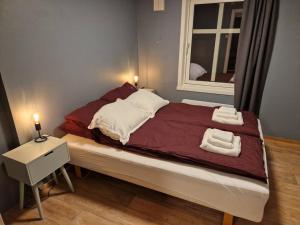 1 dormitorio con 1 cama con 2 toallas en Apartment next to the bridge, en Tromsø