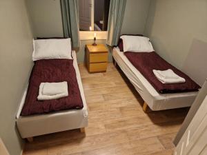 Duas camas num quarto com piso em madeira em Apartment next to the bridge em Tromsø