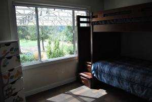 ein Schlafzimmer mit einem Etagenbett und einem großen Fenster in der Unterkunft Casa de campo en ruta del vino in Villa de Juárez