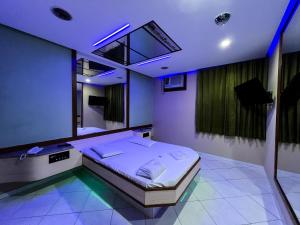 a bedroom with a bed in a room with purple lights at Status Motel in Niterói
