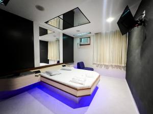 Habitación con cama y TV. en Status Motel, en Niterói