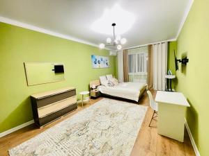 a green room with a bed and a table at # 22 Яркая и уютная квартира MODERN in Atyrau