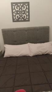 a bed with two pillows and a headboard at Cabaña a pasos del lago in Tandil