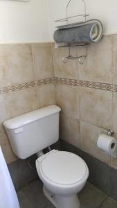 uma casa de banho com um WC e um rolo de papel higiénico em Cabaña a pasos del lago em Tandil