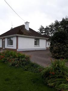 une maison blanche avec un toit et une cour dans l'établissement Family Home, 20 mins from Youghal Beach, à Killeagh